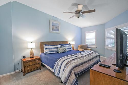 a bedroom with a bed and a ceiling fan at Updated 2BR Siesta Key condo with private beach access in Siesta Key