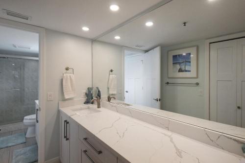 a bathroom with a sink and a large mirror at 2nd floor lakeview condo In Siesta Key with private beach access in Siesta Key