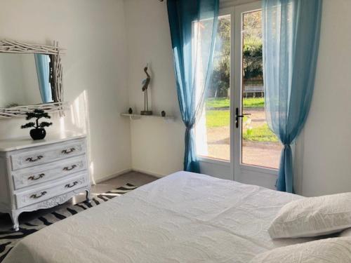 une chambre avec un lit, une commode et une fenêtre dans l'établissement Maison provençale de Plain pied avecGrand jardin et Piscine, à Aubagne