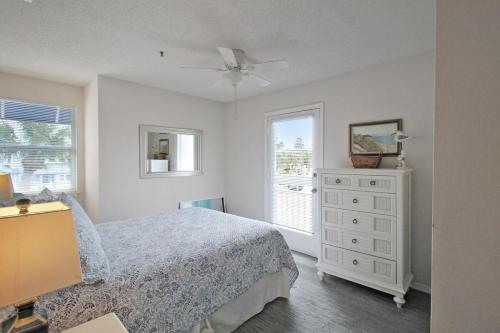 a bedroom with a bed and a dresser and a window at 2nd floor lakeview condo In Siesta Key with private beach access in Siesta Key