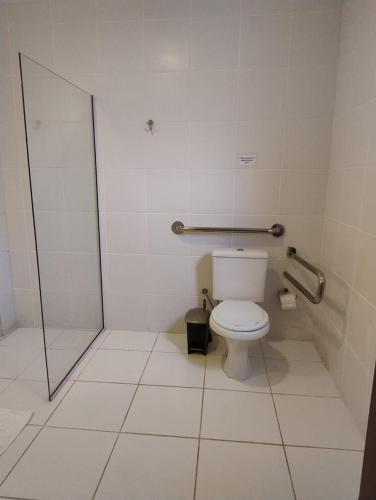 a bathroom with a toilet and a shower stall at Colônia de Férias Beleza e Arte in Caraguatatuba
