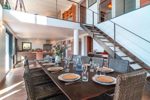 une salle à manger avec une longue table et des chaises dans l'établissement Les Paludiers - Jolie Maison à St Philibert, à Saint-Philibert