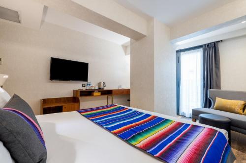a hotel room with a bed and a flat screen tv at Hay Hotel Alsancak in Izmir