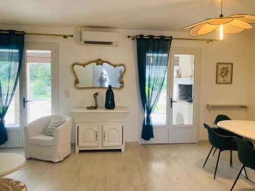 a living room with a chair and a mirror at Maison provençale de Plain pied avecGrand jardin et Piscine in Aubagne