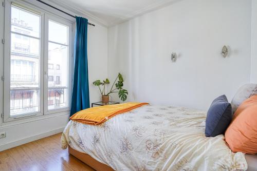 une chambre avec un lit et une grande fenêtre dans l'établissement Cloysia Studio 18eme - 15 min à pied de montmartre, à Paris