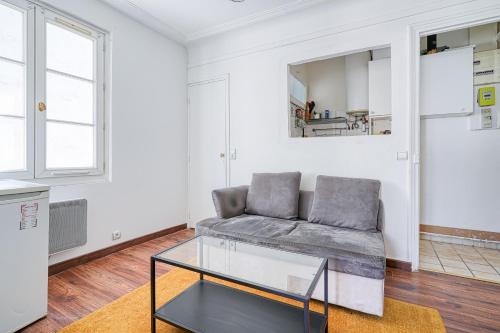 un salon avec un canapé et une table en verre dans l'établissement Cloysia Studio 18eme - 15 min à pied de montmartre, à Paris