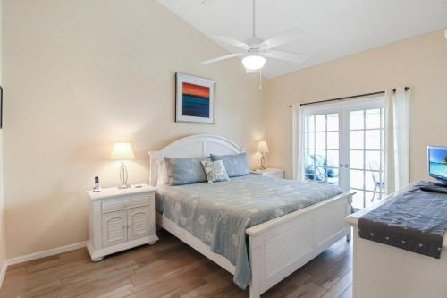 a bedroom with a bed and a ceiling fan at Spacious 3BR Siesta Key condo with private beach access in Siesta Key