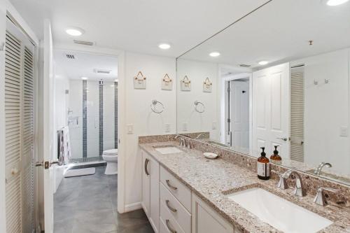 a white bathroom with two sinks and a toilet at Spacious 3BR Siesta Key condo with private beach access in Siesta Key