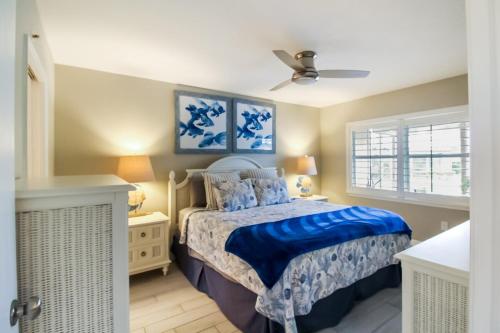 een slaapkamer met een bed en een plafondventilator bij Lakefront Siesta Key condo with private beach access in Siesta Key