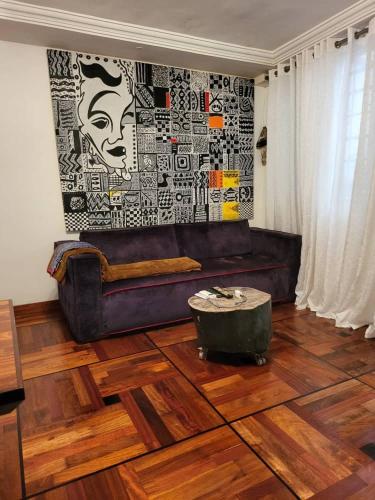 a living room with a brown leather couch and a wall at Villa Piagne Bastos in Yaoundé