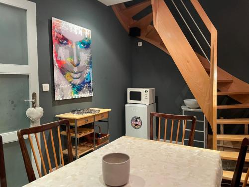 une cuisine avec une table et un tableau mural dans l'établissement Gite L Institut, à Jeuxey