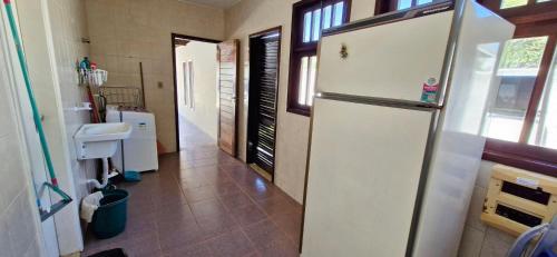 a kitchen with a white refrigerator and a tile floor at COBUV0100 - Condominio Dunas de Busca Vida in Pontão