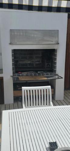 a white bench sitting in front of a fireplace at Salt Bungalow Yzerfontein in Yzerfontein