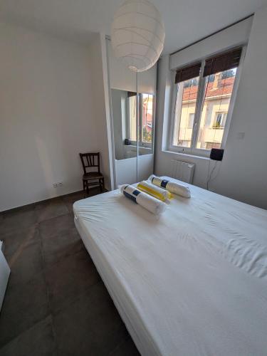 un grand lit blanc dans une chambre avec une fenêtre dans l'établissement La Vigie, à Saint-Raphaël