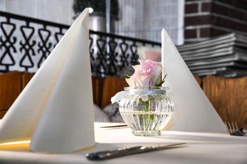 a glass vase with a flower in it on a table at Landhotel Adler in Deggenhausertal