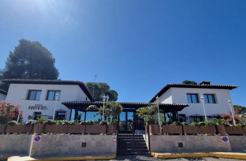 a white building with a gate in front of it at Hotel Boutique Mirasierra in Villacañas