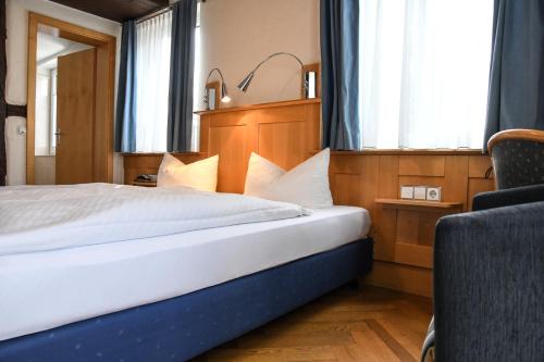 a hotel room with a bed and a chair at Landhotel Adler in Deggenhausertal