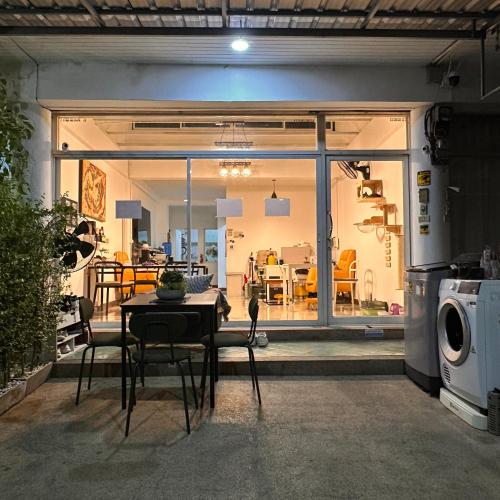 a living room with a table and a dining room at 소다호스텔 Soda HosteL in Chiang Mai
