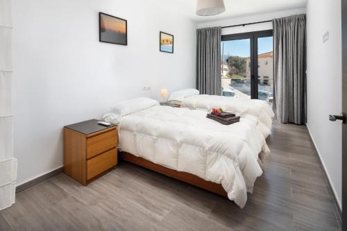zwei Betten in einem Zimmer mit weißen Wänden in der Unterkunft Villa La Fuente in Periana