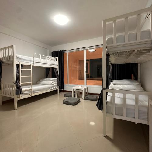 ein Zimmer mit zwei Etagenbetten und einem Spiegel in der Unterkunft 소다호스텔 Soda Hostel in Chiang Mai