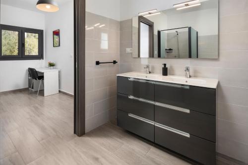 ein Badezimmer mit Waschbecken und Spiegel in der Unterkunft Villa La Fuente in Periana