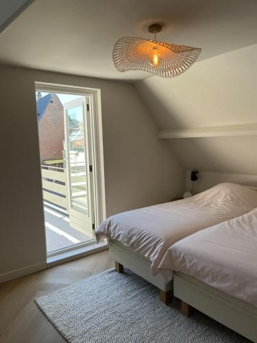 a bedroom with a bed and a large window at Salty Breeze in Noordwijk