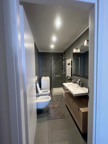 a bathroom with two sinks and a toilet and a shower at La casa di Eli in Genoa