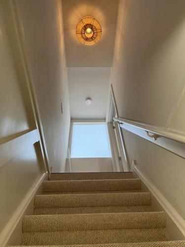 a staircase with a chandelier and a light on the ceiling at Salty Breeze in Noordwijk