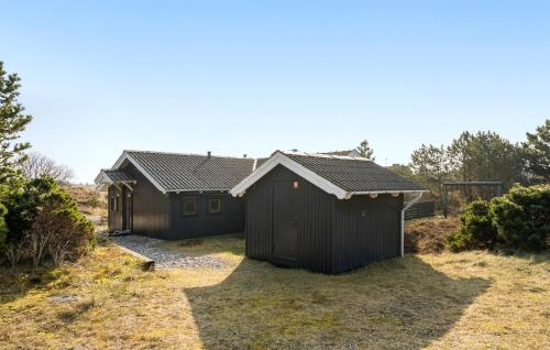 a house with two sheds in a yard at Lovely Home In Ringkøbing With Sauna in Ringkøbing