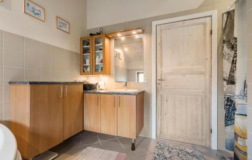 a small kitchen with a sink and a door at Lovely Home In Ringkøbing With Sauna in Ringkøbing