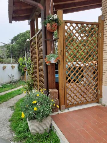 a wooden gate with two potted plants and flowers at Palma House in La Massimina-Casal Lumbroso