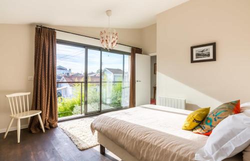 une chambre avec un lit et une grande fenêtre dans l'établissement Beautiful loft Bordeaux Cité du Vin, à Bordeaux
