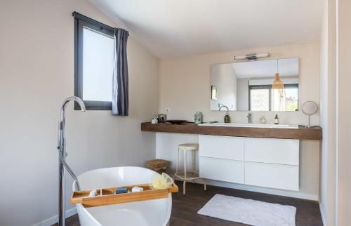 une salle de bain avec une baignoire blanche et un lavabo dans l'établissement Beautiful loft Bordeaux Cité du Vin, à Bordeaux