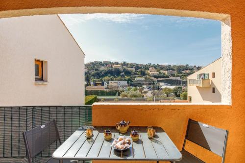 une table et des chaises sur un balcon avec vue dans l'établissement Saint Charles YourHostHelper, à Saint-Raphaël