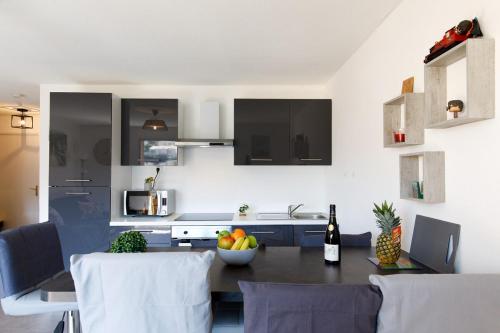 une cuisine avec une table avec un bol de fruits dessus dans l'établissement Saint Charles YourHostHelper, à Saint-Raphaël