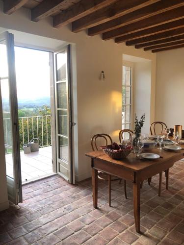 une salle à manger avec une table et un balcon dans l'établissement La Petite Montjoie - Maison vigneronne, à Tharoiseau