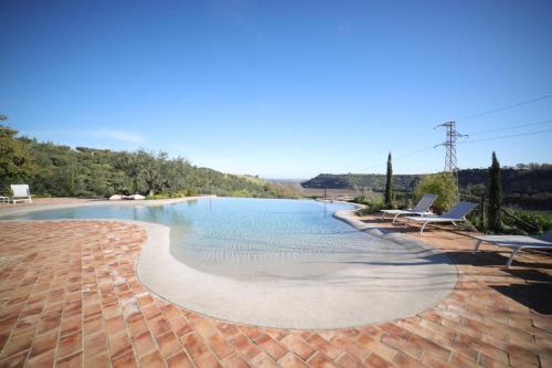 a swimming pool with two lounge chairs next to it at Castello di Serragiumenta in Firmo