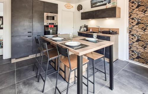 une cuisine avec un grand îlot en bois et des tabourets de bar dans l'établissement 2 Bedroom Gorgeous Home In Saint-Pabu, à Saint-Pabu