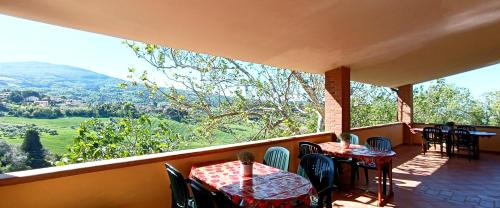 two tables and chairs on a balcony with a view at agriturismo macchia al pino in Pomaia