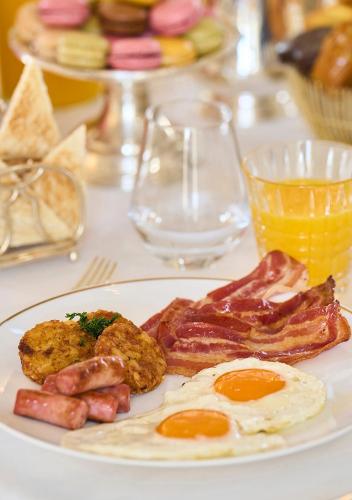a plate of breakfast food with eggs bacon and meat at Mandarin Oriental Ritz, Madrid in Madrid