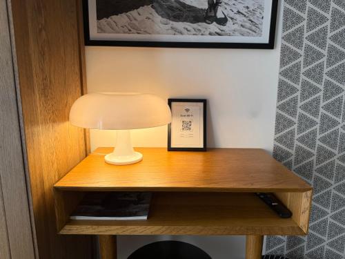 a table with a lamp and a picture on it at Origines in Tautavel
