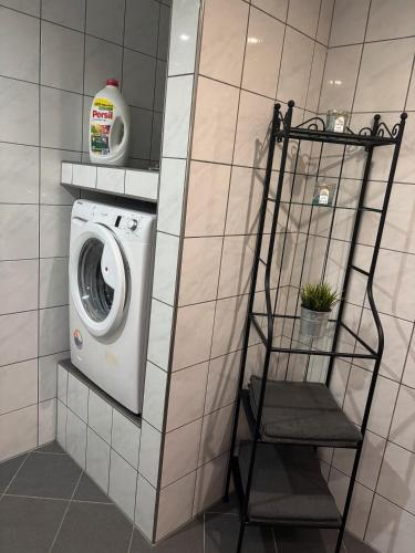 a washer and dryer in a tiled bathroom at Eifel im Herzen in Hambuch