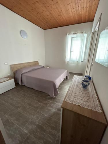 a bedroom with a bed and a wooden ceiling at Family home in Donigala Fenughedu