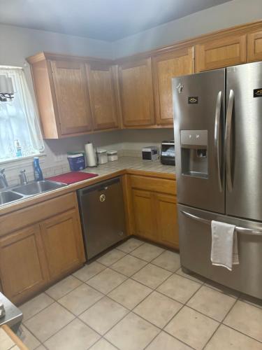 een keuken met houten kasten en een roestvrijstalen koelkast bij The House in Mena