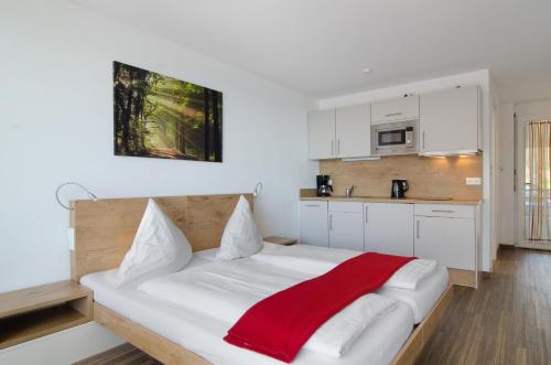 a bedroom with a bed with a red blanket on it at Gästehaus D i c k r e i t e r in Immenstaad am Bodensee
