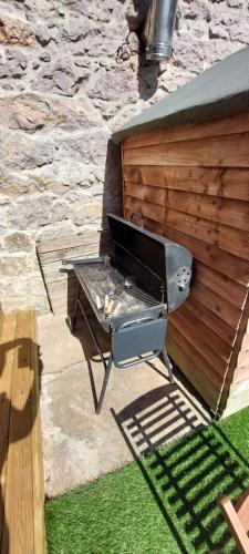 a barbecue grill sitting next to a building at Detached with Amazing Sea Views and Hot Tub in Llandudno