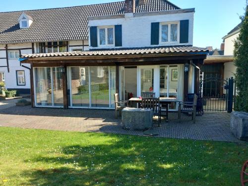 a house with a screened in porch with a table at Stegelshof 1 in Eygelshoven