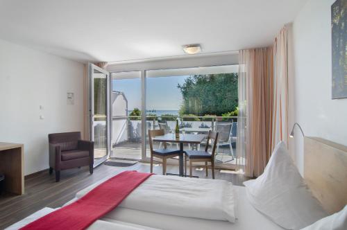 a bedroom with a bed and a balcony with a table and chairs at Gästehaus D i c k r e i t e r in Immenstaad am Bodensee