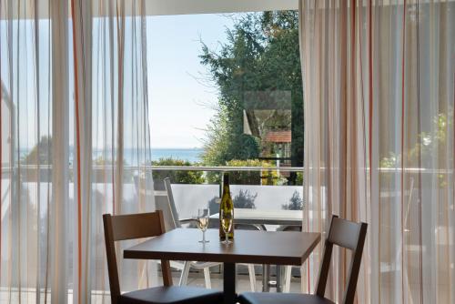 a dining room table with chairs and a window at Gästehaus D i c k r e i t e r in Immenstaad am Bodensee