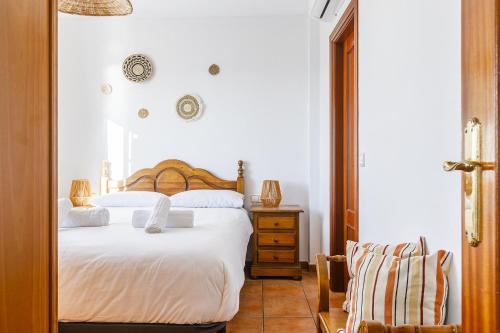 een slaapkamer met een wit bed en een stoel bij A&N Los Carmenes, Torre del Mar in Torre del Mar